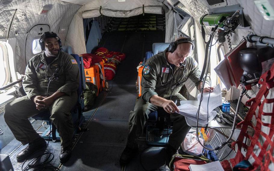 Two members of the crew of a US Coast Guard HC-144 Ocean Sentry airplane while on a reconnaissance flight over the Florida Straits and the Bahamas.