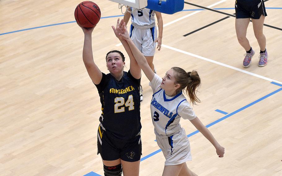 Ansbach sophomore Kennedy Lange goes up for a layup as Hohenfels freshman Evelyn Chernock defends during pool-play action of the DODEA European basketball championships on Feb. 14, 2024, at the Wiesbaden Sports and Fitness Center on Clay Kaserne in Wiesbaden, Germany.