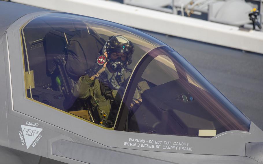 Marine Corps test pilot Lt. Col. Robert Guyette holds up a JS Izumo patch after landing an F-35B Lightning II aboard the Japanese carrier on Sunday, Oct. 3, 2021.