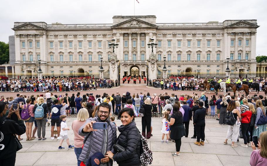 Members of the public watch the Changing of the Guard ceremony at Buckingham Palace, London, Monday August 23, 2021.