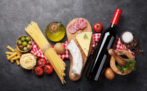 Photo Of Italian cuisine food ingredients. Pasta, cheese, salami, olives and wine. Top view flat lay on stone table