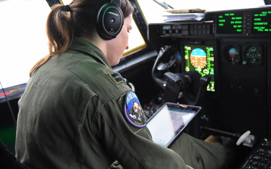 Capt. Tiffany Haines goes over a preflight checklist before a training flight on Friday, March 18, 2022, at Ramstein Air Base, Germany. A member of the 37th Airlift Squadron, Haines is among a small group of women in a unit that is busy shuttling personnel and supplies in support of the NATO mission in Eastern Europe. Haines led an all-women, three-aircraft formation as part of her training.