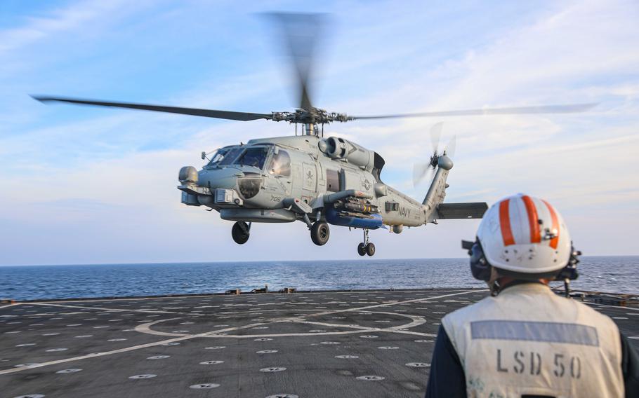 Petty Officer 1st Class Brandon Nobles, attached to Helicopter Maritime Strike Squadron 70, observes an MH-60R Sea Hawk helicopter during flight operations aboard the dock landing ship USS Carter Hall, Oct. 27, 2023. 