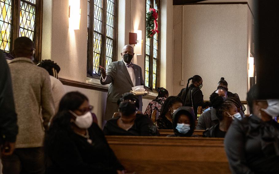 Hari Close, a funeral home director, conducts a memorial service in December 2021 for an employee’s family member at Perkins Square Baptist Church in Baltimore.