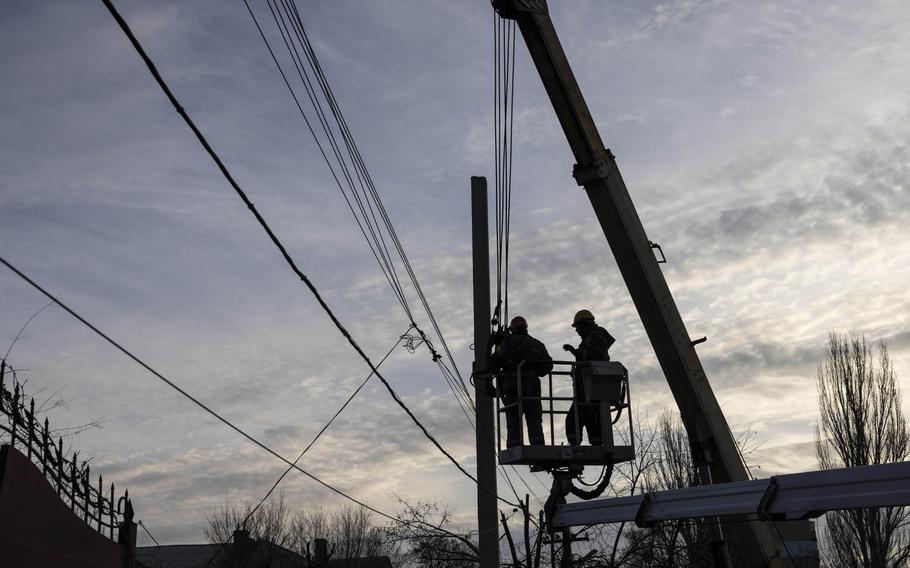 Workers fix power lines in a residential neighborhood in Dnipro, Ukraine, on Dec. 1. 