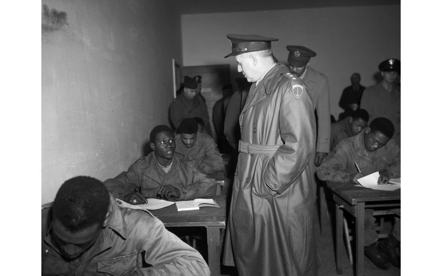 Lt. Gen. Clarence R. Huebner talks to T/5 T.C. Thompson in one of the classrooms at the Kitzingen Basic Training Center for Negro troops. Classroom instruction ranges from literacy training to courses on high school level. 