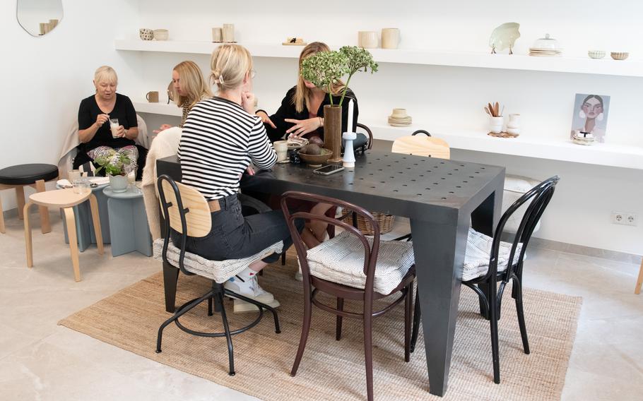 Customers sit at a cafe table.
