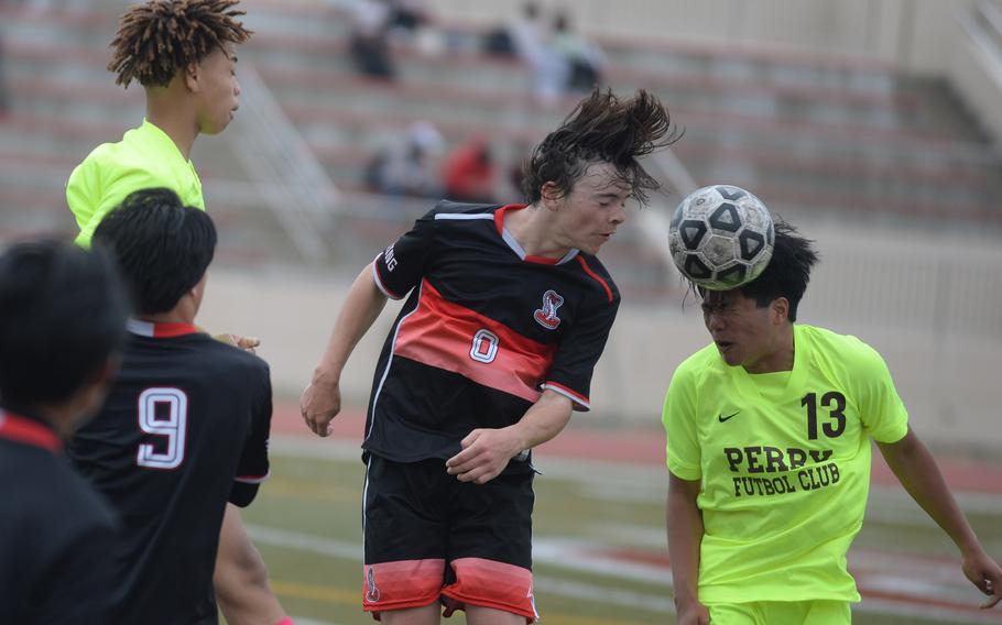 E.J. King's N.J. Reed and Matthew C. Perry's Zach Cruz go up to head the ball during Friday's DODEA-Japan boys soccer match. The host Samurai won 1-0.