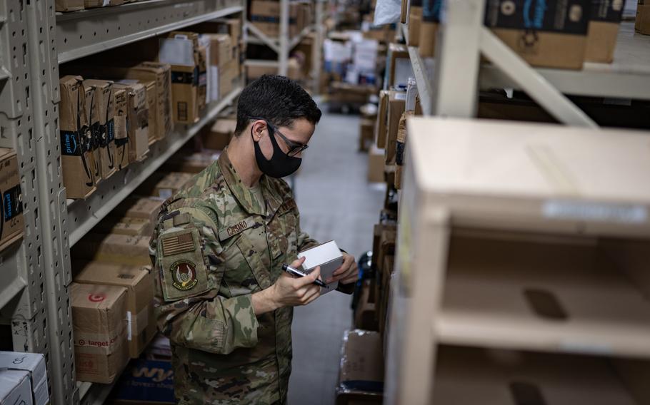 Staff Sgt. Jesse Castano, a postal supervisor assigned to the 374th Force Support Squadron, registers a package into the postal system at Yokota Air Base, Japan, in 2020. The military postal service rescinded an announcement it made last month that it would halt services for overseas retirees and others starting in August.