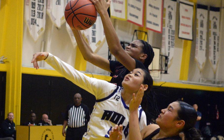 Kinnick's KaMiyah Dabner skies above Academy's Maria Paulino for a rebound.