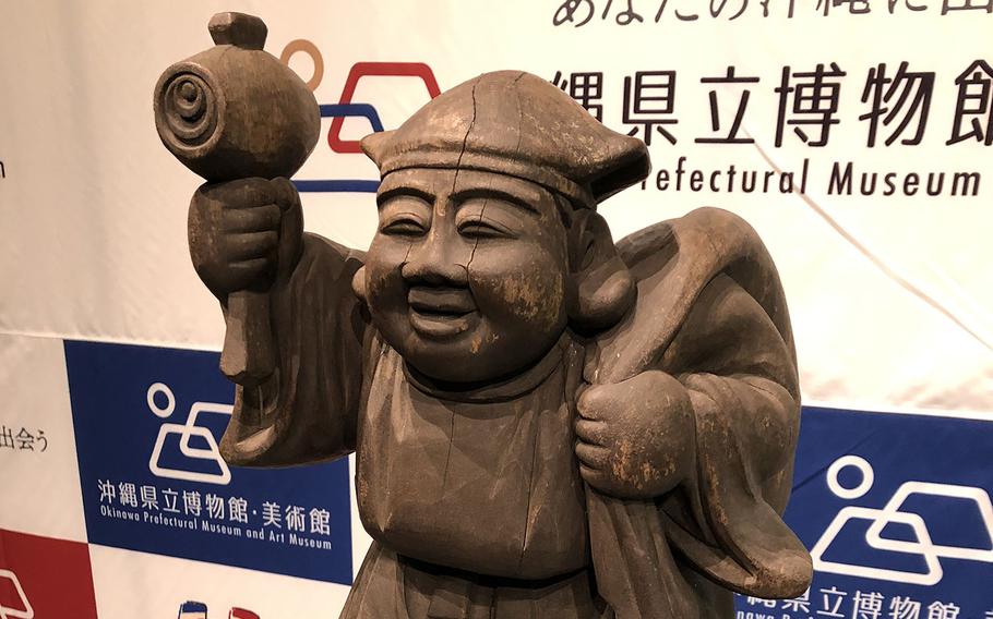 This 22-inch Daikokuten statue, unveiled this winter at the Okinawa Prefectural Museum and Art Museum, depicts a smiling man holding a mallet and standing on bales of rice. 