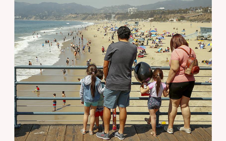At the Santa Monica pier, a family watches beachgoers in 2021. 