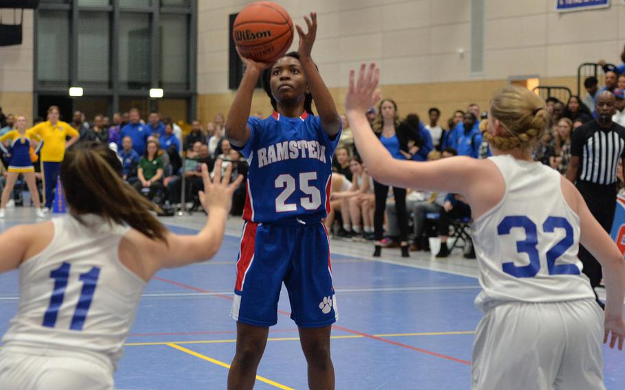 Ramstein’s Bralyn Jones aims for the basket over Wiesbaden’s Eszie Munoz, left, and  Gwen Icanberry in the Division I championship game at the DODEA-Europe basketball championships in Ramstein, Germany, Feb. 18, 2023. The Warriors beat the Royals 43-34 to take the title.