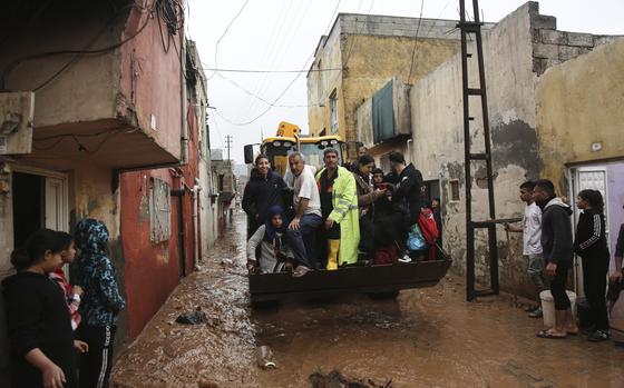 People are rescued during floods after heavy rains in Sanliurfa, Turkey, Wednesday, March 15, 2023. Floods caused by torrential rains hit two provinces that were devastated by last month's earthquake, killing at least 10 people and increasing the misery for thousands who were left homeless, officials and media reports said Wednesday. At least five other people were reported missing. (Hakan Akgun/DIA via AP)