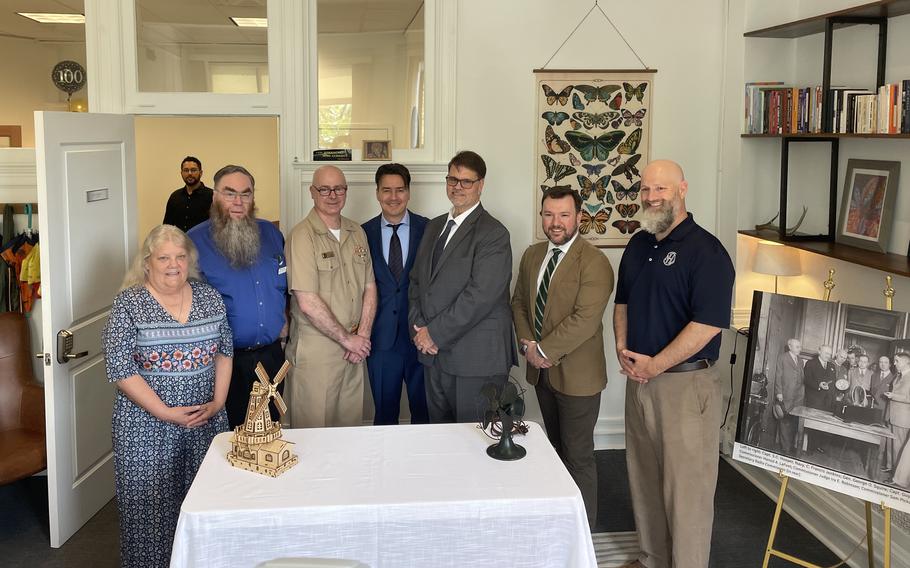 A photo of a group of people standing at a table.