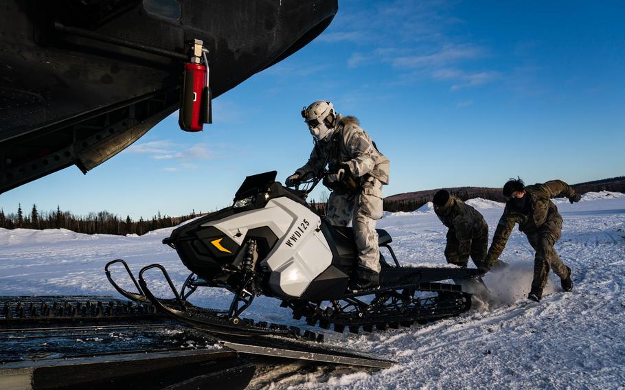 U.S. Army Special Forces and Danish special operators training on loading and unloading snowmobiles. 