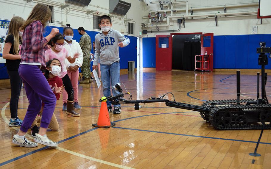 Lanham Elementary School students observe and control a robot used by Marine Corps explosive ordnance teams during a STEAM event at Naval Air Facility Atsugi, Japan, May 27, 2021. 