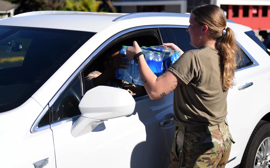 Army Cpl. Alexandria Ayotte passes out water to residents of Aliamanu Military Reserve, Feb. 3, 2022, in the wake of tap water contamination from the Red Hill Bulk Fuel Storage Facility near Joint Base Pearl Harbor-Hickam, Hawaii.