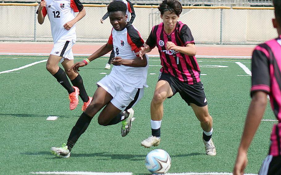 Kinnick's Leon Awesso and Kadena's Frank Stare chase the ball during the Boys D-1 final.The Panthers won 5-2.