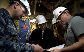 Stephen Shedd, then-commander of the guided-missile destroyer USS Milius, discusses blueprints for the Consolidated Afloat Networks and Enterprise Services program with engineers in 2013.