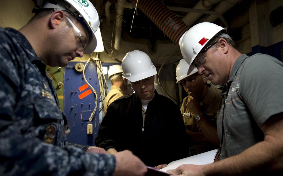 Stephen Shedd, left, then-commander of the guided-missile destroyer USS Milius, discusses blueprints for the Consolidated Afloat Networks and Enterprise Services program with engineers in 2013.