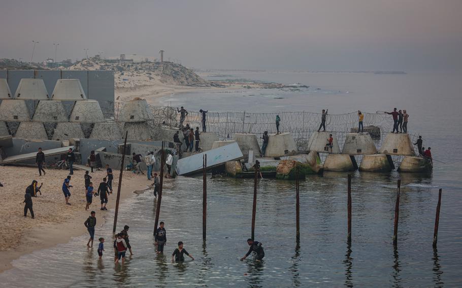 Palestinians on the beach in the Rafah refugee camp, near the border separating the Gaza Strip and Egypt, on Tuesday, Feb. 13, 2024.