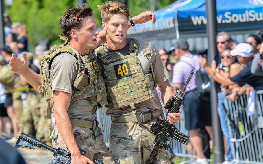 Army 1st Lt. Andrew Winski, left, and Sgt. Matthew Dunphy of the 75th Ranger Regiment hug briefly after crossing the finish line to win the 2024 Best Ranger Competition on Fort Moore, Ga., on Sunday, April 14, 2024. Their victory handed the Ranger Regiment its fourth consecutive victory in the grueling, three-day military skills challenge. 