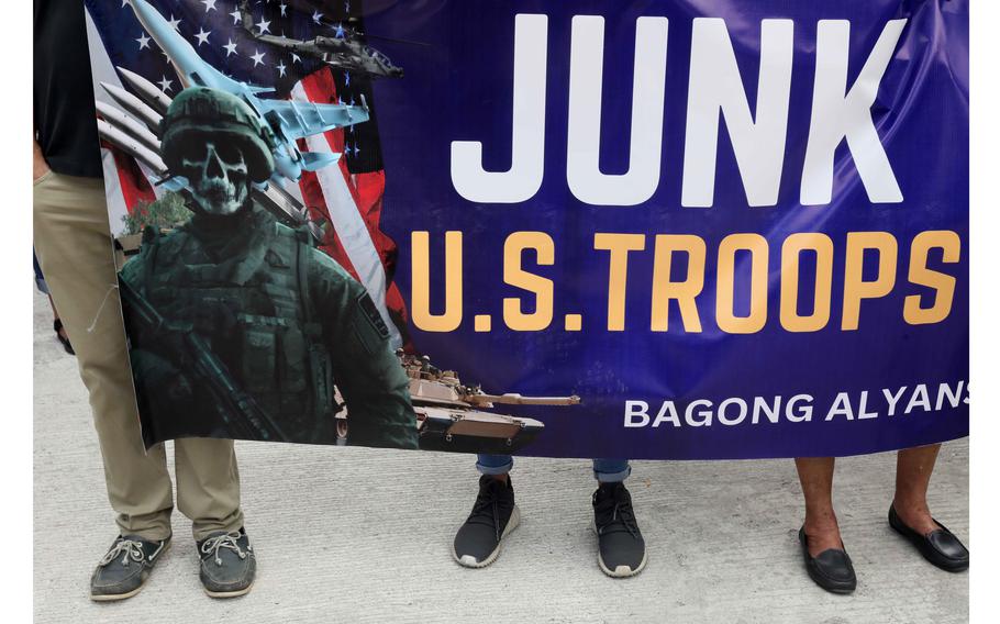 Protesters display placards and burn a mock US  flag to protest the visit of US Defense Secretary Lloyd Austin to the Philippines Thursday, Feb. 2, 2023, at Camp Aguinaldo in suburban Quezon city northeast of the capital Manila. 