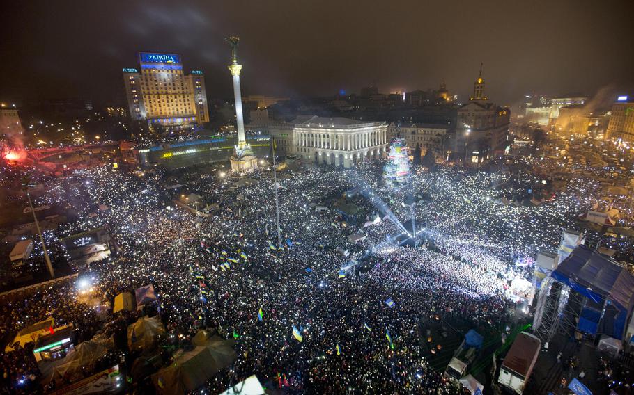 In this Jan. 1, 2014, file photo Pro-European Union activists hold lights as they sing the Ukrainian national anthem, celebrating the New Year in Kyiv's main square. At least 100,000 Ukrainians gathered in a sign of support for integration with Europe. On Nov. 21, 2023, Ukraine marks the 10th anniversary of the uprising that eventually led to the ouster of the country’s Moscow-friendly president.