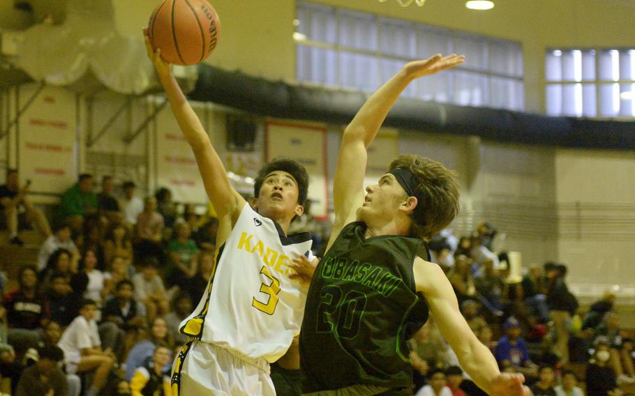 Kadena's Jaden Vergara drives and shoots against Kubasaki's Luca Lantz during Friday's DODEA-Okinawa boys basketball game. The Panthers won 61-52.