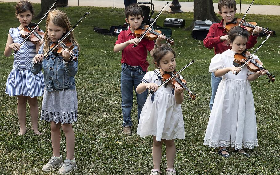 Young students from Drew Robertson's music studio in Manassas, Va., serenade visitors to the National World War II Memorial in Washington, D.C., on the 79th anniversary of the start of the D-Day invasion, Tuesday, June 6, 2023.