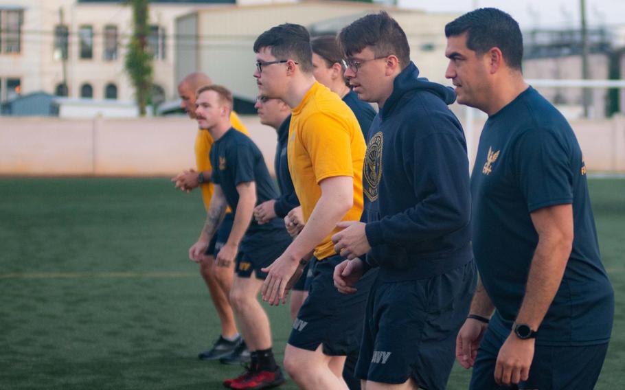 Personnel assigned to the aircraft carrier USS John C. Stennis warm up before their phyical readiness test in Newport News, Virginia, Oct. 14, 2021. The Navy has announced that it will remove failed fitness tests from sailor records, though sailors must meet standards moving forward.