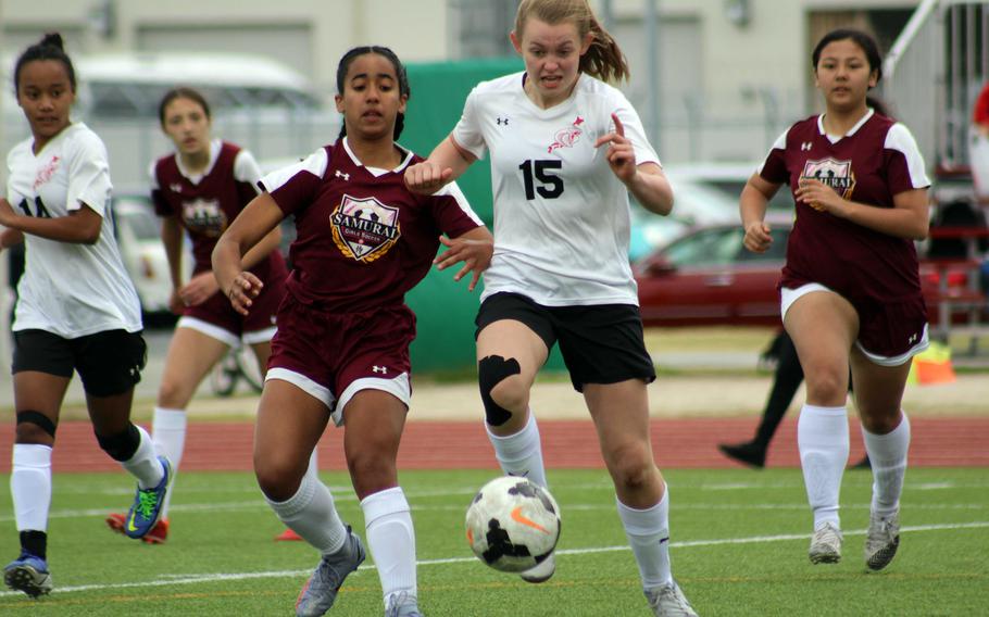 E.J. King's Madylyn O'Neill dribbles against Matthew C. Perry's Ivanelis Nieves during Saturday's DODEA-Japan soccer match. The teams tied 2-2.