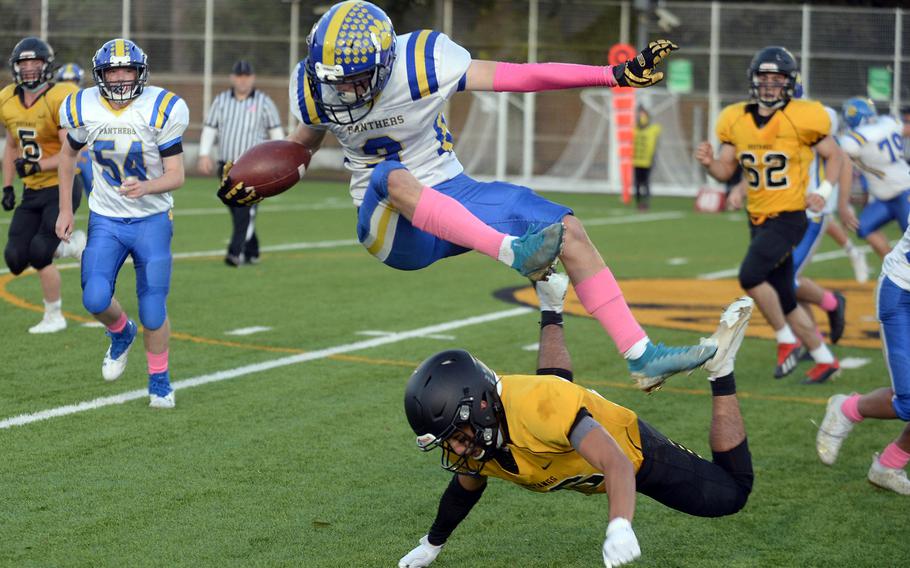 Yokota's Caleb Jones leapfrogs American School In Japan defender Stefan Merino.