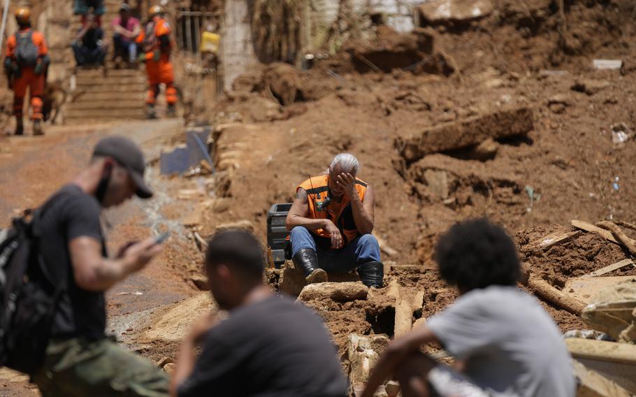 A rescue worker takes a break on the second day of rescue efforts after deadly mudslides in Petropolis, Brazil, Thursday, Feb. 17, 2022. 