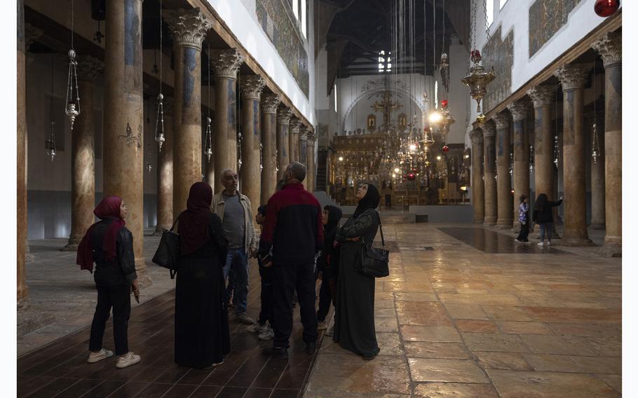 Palestinian Muslims visit the Church of the Nativity in Bethlehem on Dec. 21, 2023. The basilica, shared by the Catholic, Greek Orthodox and Armenian Apostolic churches, is uncharacteristically quiet during the Christmas season this year. 