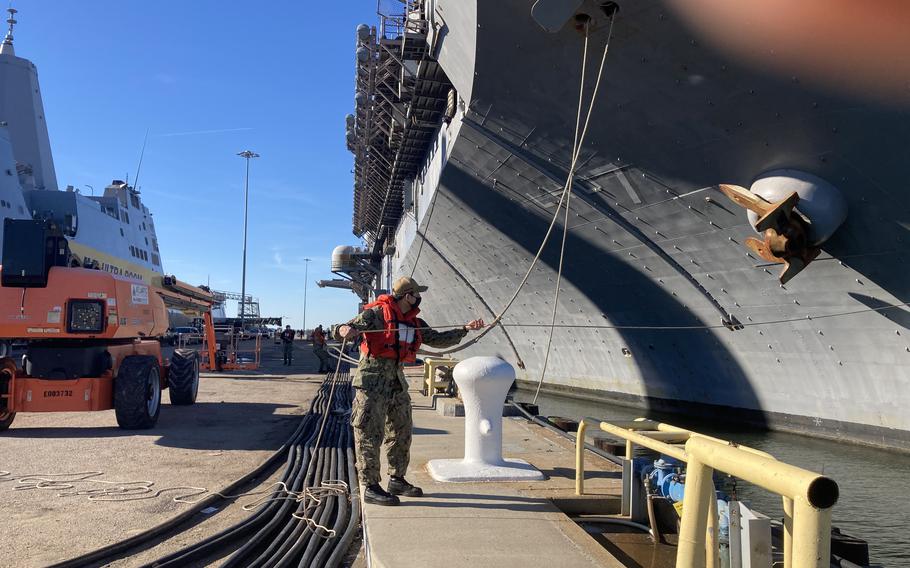 As USS Iwo Jima nears the end of its homeport shift to Norfolk, a sailor hauls in a mooring line to secure the ship at Naval Station Norfolk.