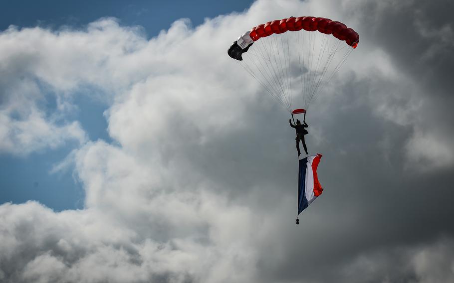 A French paratrooper flies a large French flag over landing site "Virgule," near Berlats, France, May 27, 2022. American paratroopers used the landing site when they jumped into Nazi-held France to support French underground resistance fighters in the Tarn region.