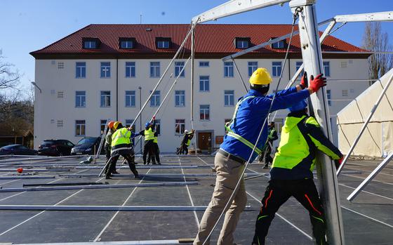 Contractors erect an expeditionary dining facility to feed an influx of new troops on Barton Barracks in Ansbach, Germany, on March 4, 2022. 