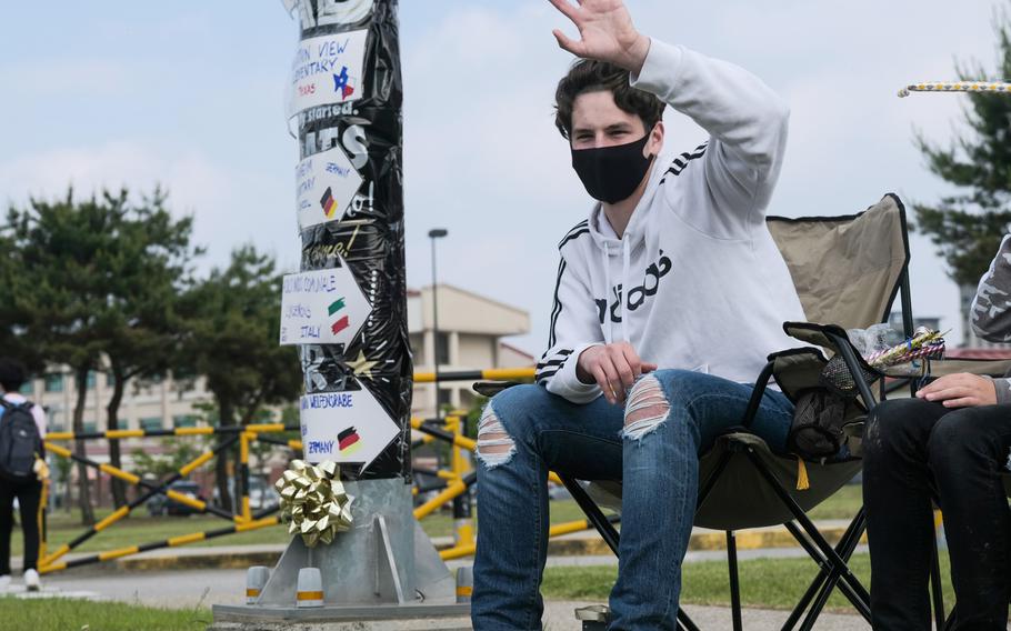 Humphreys High School senior Matthew Macy waves to his supporters during a reverse parade for soon-to-be graduates at Camp Humphreys, South Korea, Thursday, May 27, 2021.