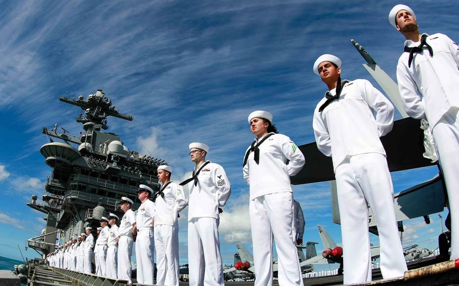 Sailors man the rails as the aircraft carrier USS Abraham Lincoln pulls into Joint Base Pearl Harbor-Hickam, Hawaii, June 26, 2022. The Navy this week canceled early separation programs for enlisted sailors and encouraged them to delay separation or retirement plans in order to keep the force fully manned and operational. 