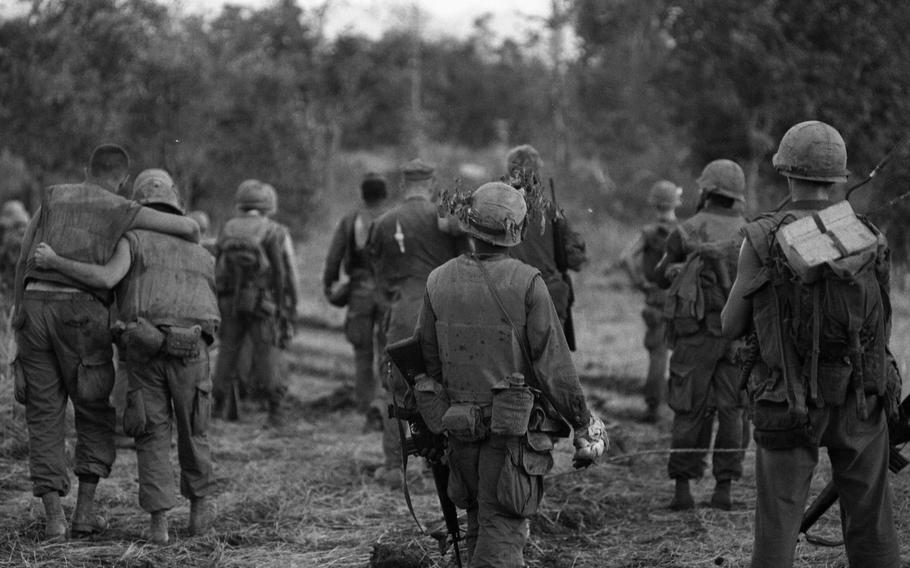 After fighting back the NVA, wounded marines of 1st Battalion, 9th Marines — supported by their battle buddies — march back to the command post. Some men were blinded in the ambush and had to be carried.