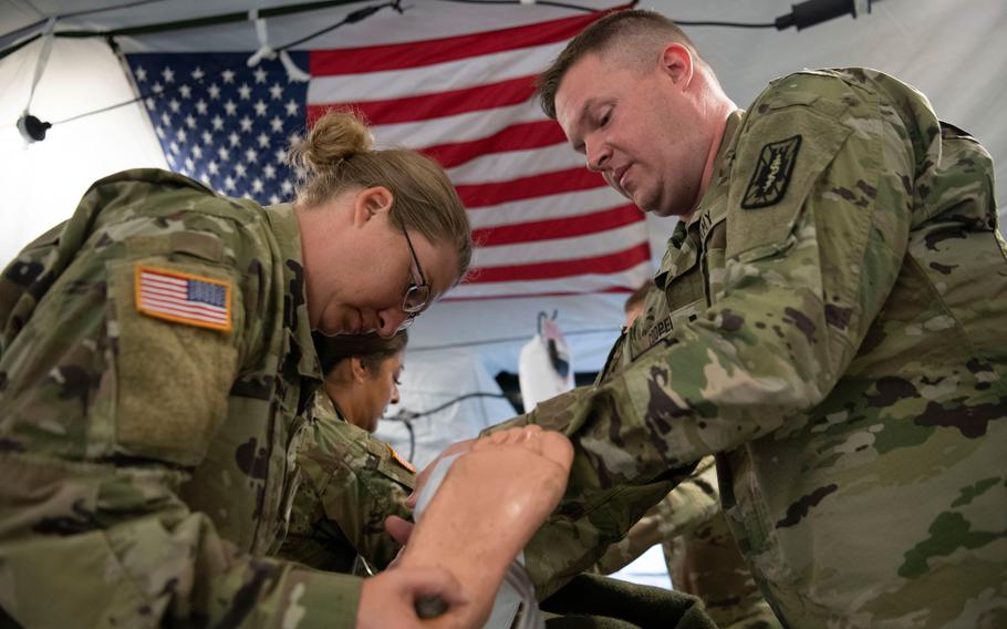 Spc. Jessica Henderson, left, and 1st Lt. David Cooper provide medical care to a mannequin during a hospital exercise at Baumholder Army Airfield, Germany, on May 17, 2024. The nurses were among roughly 200 reserve soldiers supporting the 75th Field Hospital who deployed from the U.S. to Germany to build a temporary hospital from Army pre-positioned stock.