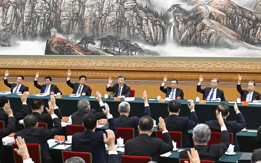 The presidium of the 20th National Congress of the Communist Party of China holds its second meeting at the Great Hall of the People as members raise their hands in Beijing, China, Tuesday, Oct. 18, 2022. 