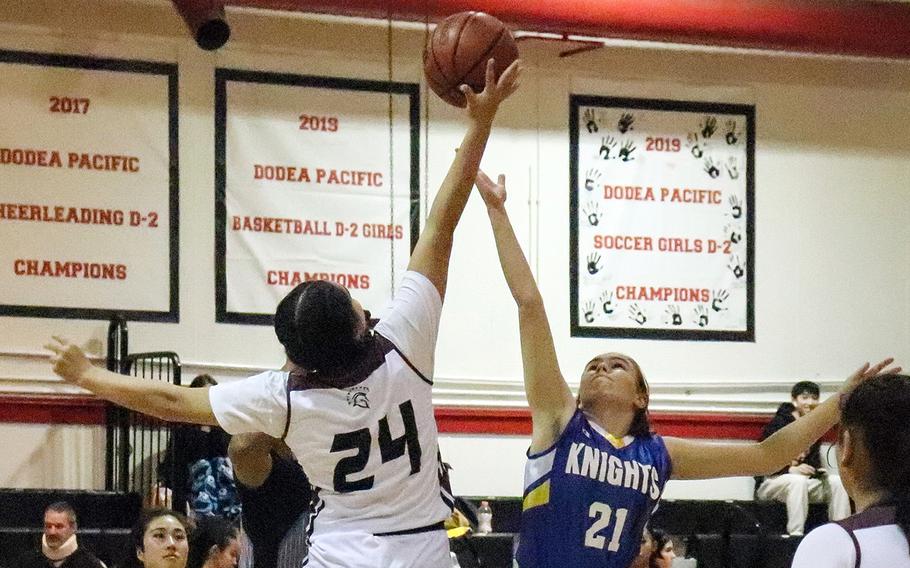 Zama's Kierstyn Aumua and Christian Academy Japan's Eryka Kindervater go up for the opening tip of Monday's Kanto Plain girls basketball game. The Trojans won 34-24.