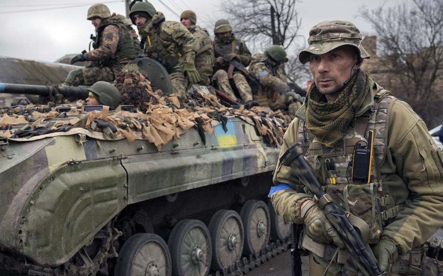 A Ukrainian service member walks next to a fighting vehicle, outside Kyiv, Ukraine, on Saturday, April 2, 2022. As Russian forces pull back from Ukraine’s capital region, retreating troops are creating a “catastrophic” situation for civilians by leaving mines around homes, abandoned equipment and “even the bodies of those killed,” President Volodymyr Zelenskyy warned.