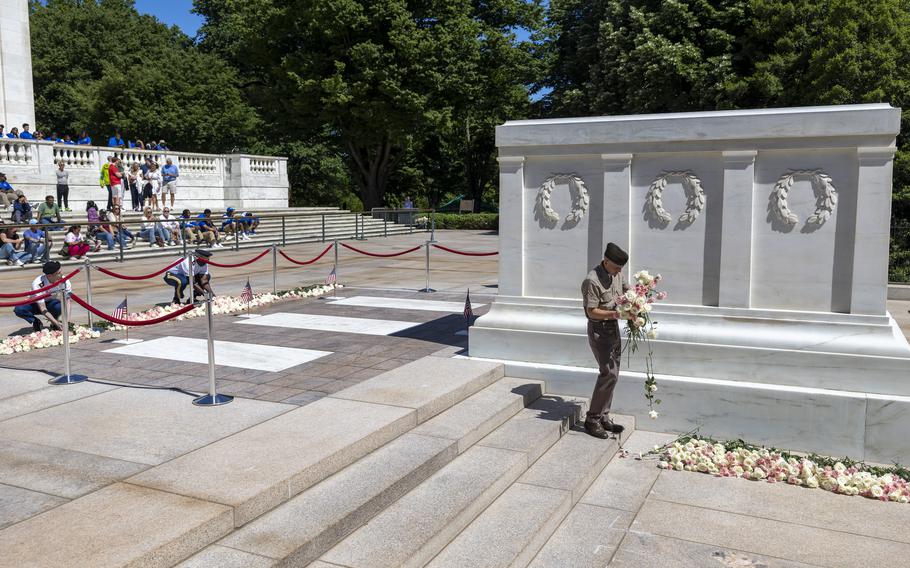 A soldier picks up and moves the flowers.
