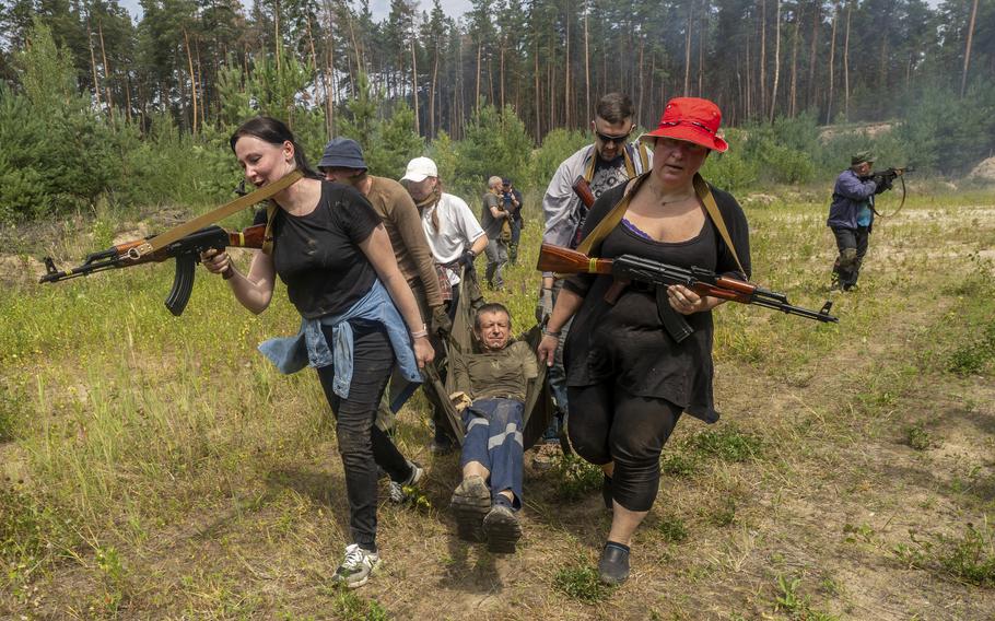 Civilians practice military skills on a training ground.