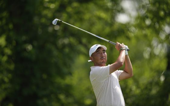 A man in a white shirt and hat raising a golf club over his shoulders.
