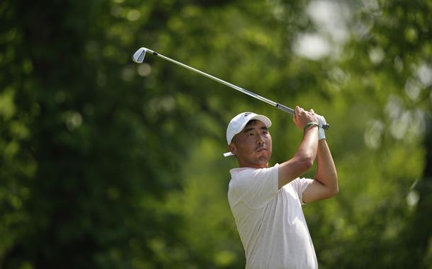A man in a white shirt and hat raising a golf club over his shoulders.